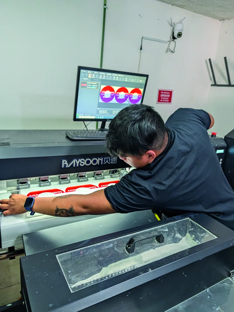 Operador supervisando impresión UV de gran formato