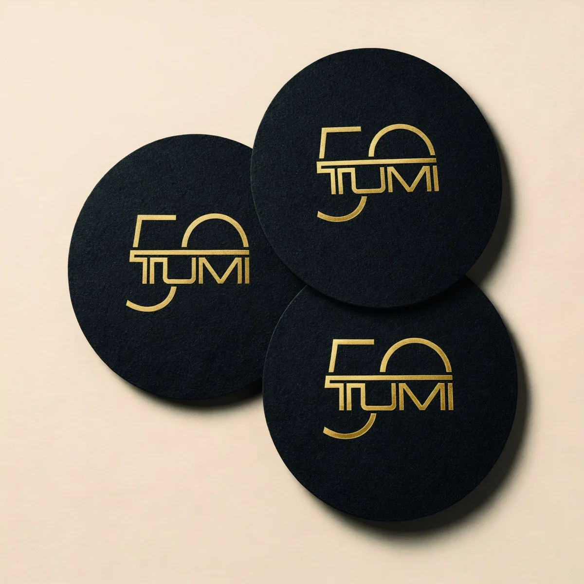 Posavasos TUMI 50 aniversario con foil dorado